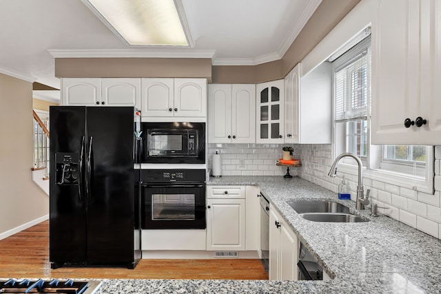 kitchen featuring black appliances, white cabinets, crown molding, sink, and light hardwood / wood-style flooring