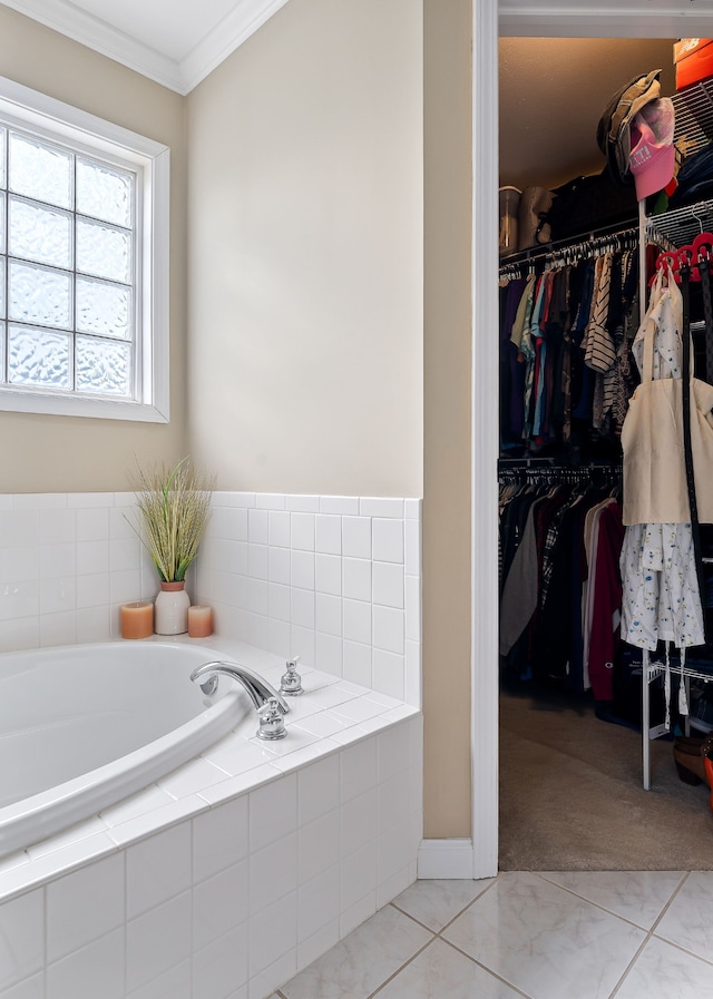 bathroom with tile patterned flooring, tiled bath, and ornamental molding