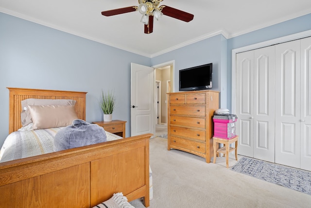 carpeted bedroom with a closet, ceiling fan, and crown molding