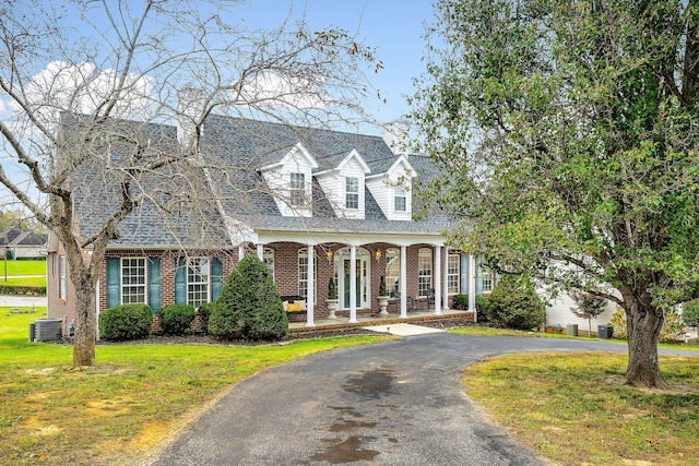 cape cod home featuring central air condition unit, a front lawn, and a porch