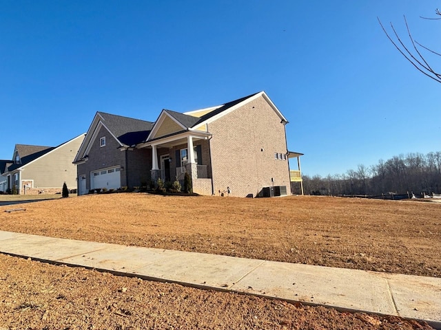 view of home's exterior featuring a yard, a garage, and a porch