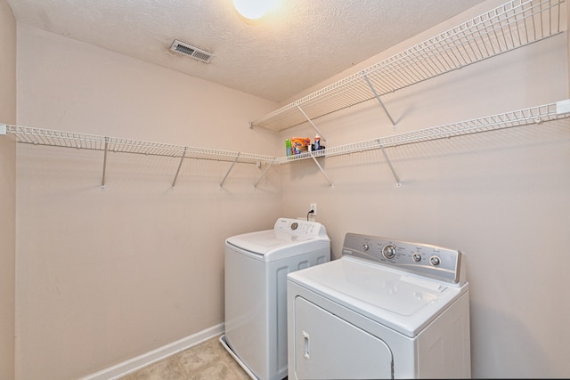 washroom with separate washer and dryer and a textured ceiling