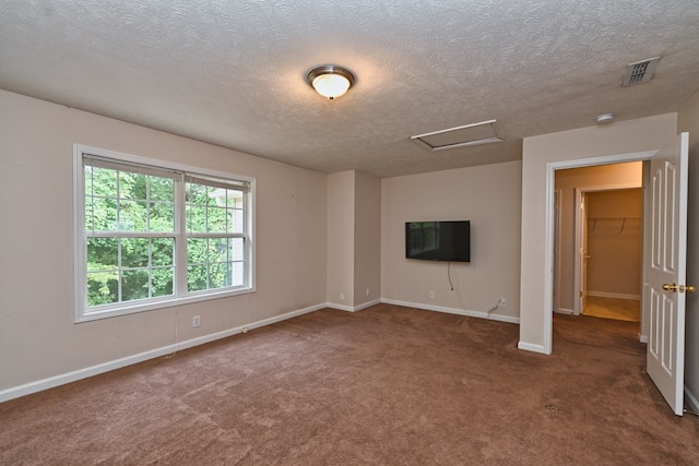 unfurnished living room with a textured ceiling and dark colored carpet