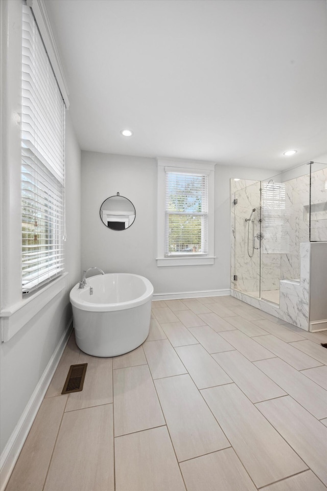 bathroom featuring tile patterned flooring, separate shower and tub, and a wealth of natural light