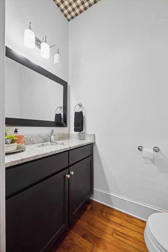 bathroom with vanity, wood-type flooring, and toilet