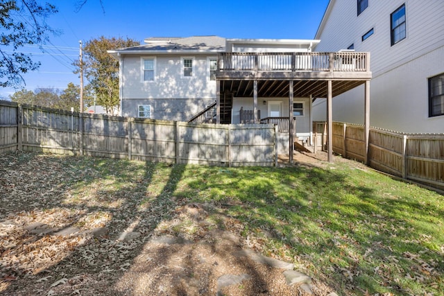 rear view of property with a yard and a wooden deck