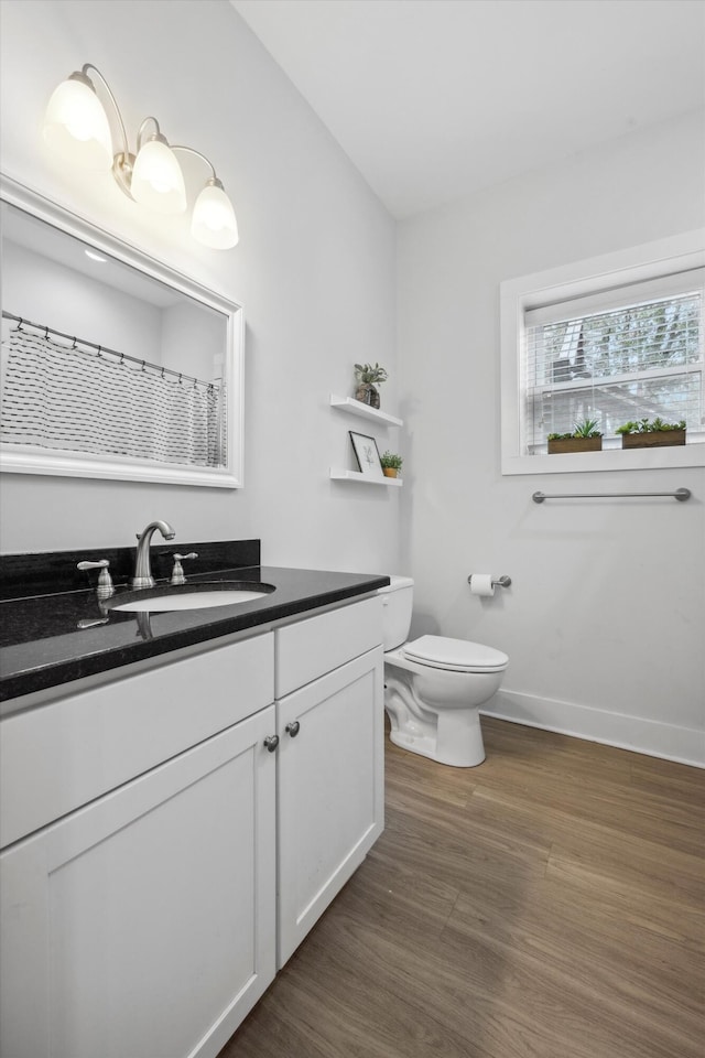 bathroom with a shower with curtain, vanity, toilet, and wood-type flooring