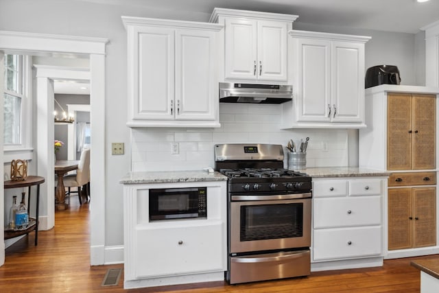 kitchen with decorative backsplash, wood-type flooring, white cabinetry, and stainless steel gas range oven