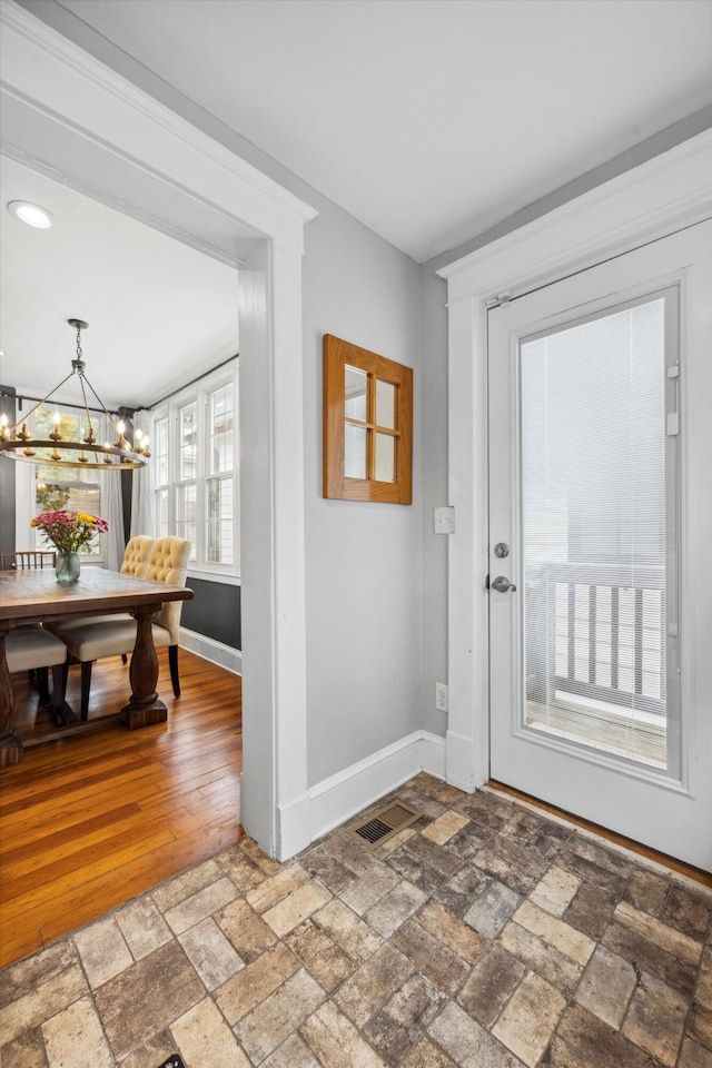 foyer with hardwood / wood-style flooring and a notable chandelier