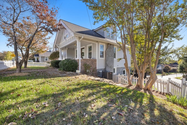 view of side of home with central AC and a yard