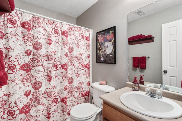 bathroom with vanity, toilet, and a textured ceiling