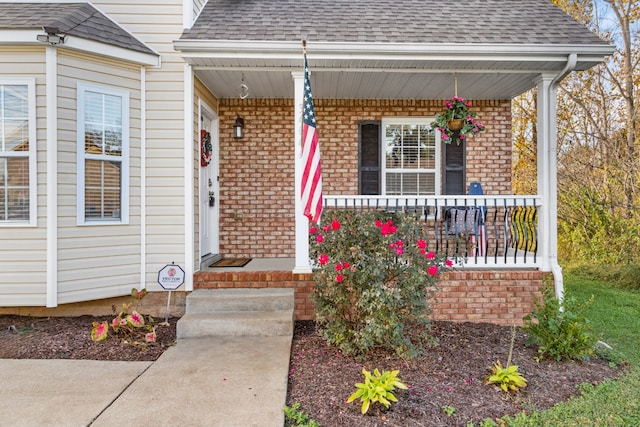 view of exterior entry featuring covered porch