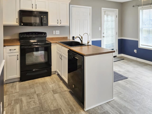 kitchen featuring white cabinetry, kitchen peninsula, sink, and black appliances