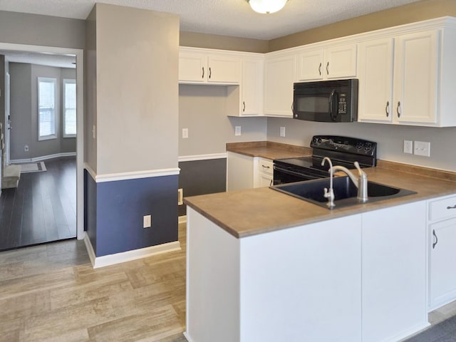 kitchen with sink, black appliances, and white cabinets