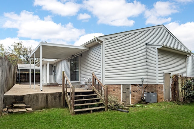 rear view of property with a deck, cooling unit, a patio area, and a lawn