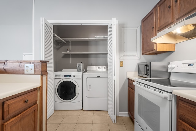 laundry area with washing machine and clothes dryer and light tile patterned floors