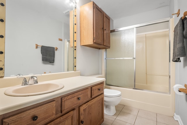 full bathroom featuring tile patterned flooring, vanity, combined bath / shower with glass door, and toilet