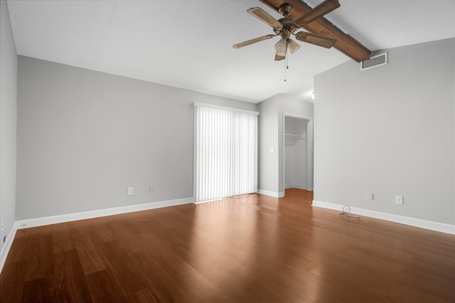 unfurnished room with ceiling fan, lofted ceiling with beams, a textured ceiling, and hardwood / wood-style flooring