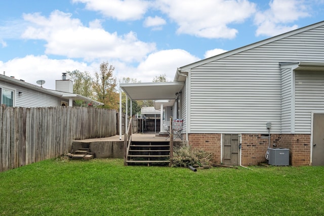 rear view of house featuring a lawn, cooling unit, and a deck