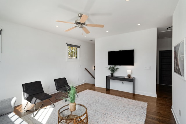 living room featuring ceiling fan and dark wood-type flooring