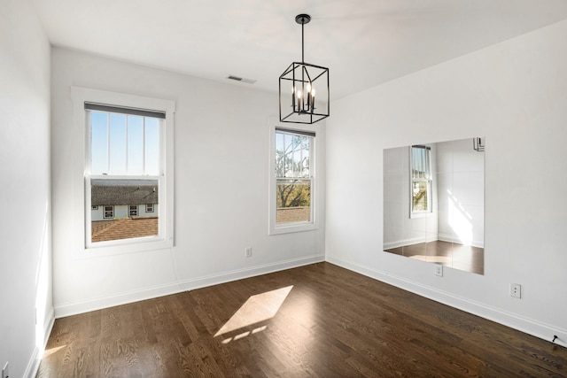 unfurnished dining area with dark hardwood / wood-style floors and a notable chandelier