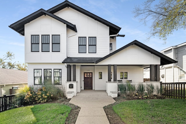 modern farmhouse with a front yard and a porch