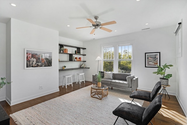 living room with ceiling fan and dark wood-type flooring