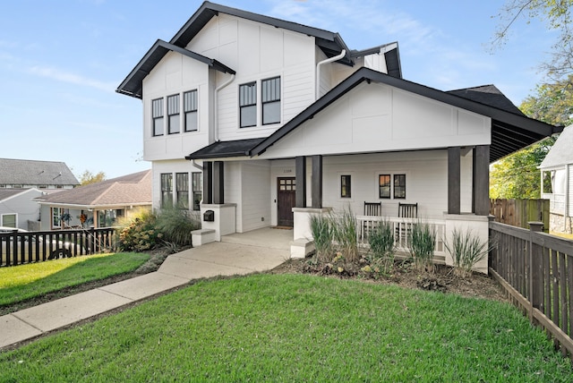 modern inspired farmhouse featuring a porch and a front yard