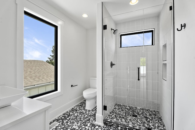 bathroom with tile patterned floors, a healthy amount of sunlight, a shower with shower door, and toilet