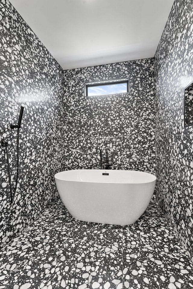 bathroom with a washtub and tile walls