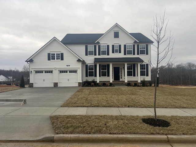 view of front of home with a garage, covered porch, and a front lawn