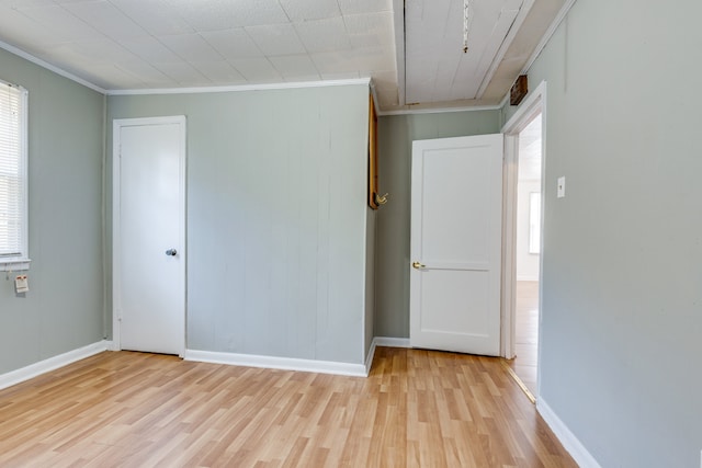 unfurnished bedroom featuring light hardwood / wood-style floors and crown molding