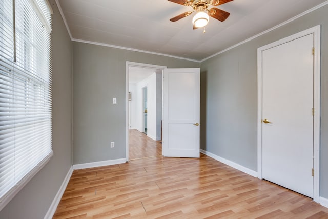 spare room with ceiling fan, ornamental molding, and light wood-type flooring