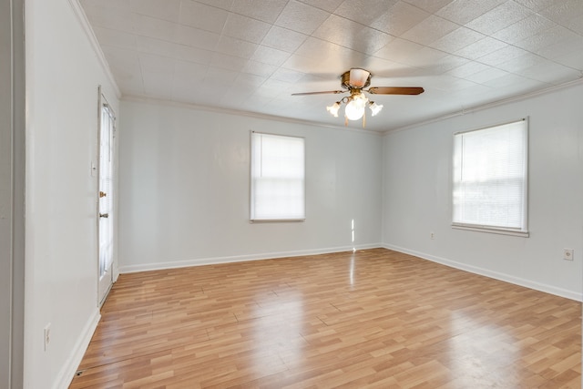 spare room featuring light hardwood / wood-style flooring, ceiling fan, a healthy amount of sunlight, and crown molding