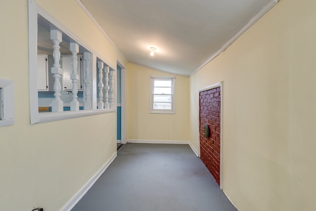 hall with lofted ceiling, ornamental molding, and concrete flooring