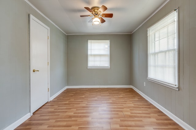 unfurnished room with ceiling fan, light hardwood / wood-style floors, crown molding, and wooden walls