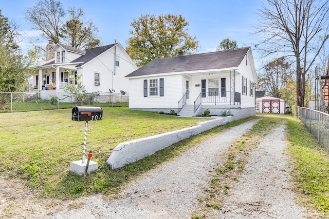 bungalow featuring an outdoor structure, a porch, and a front yard