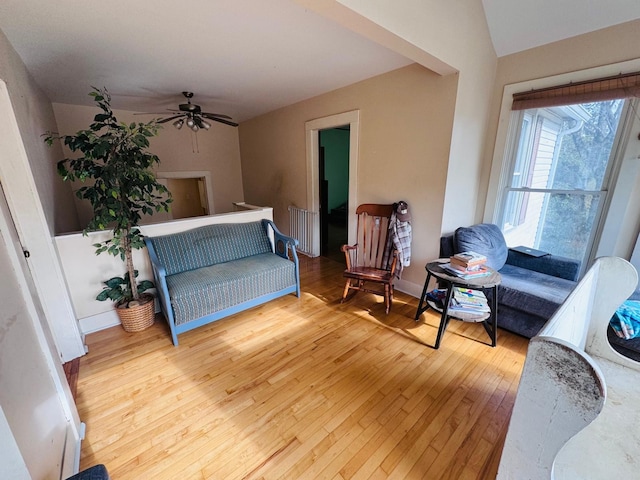 living room with ceiling fan and light hardwood / wood-style flooring