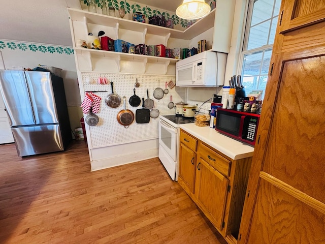 kitchen with decorative backsplash, white appliances, and light wood-type flooring