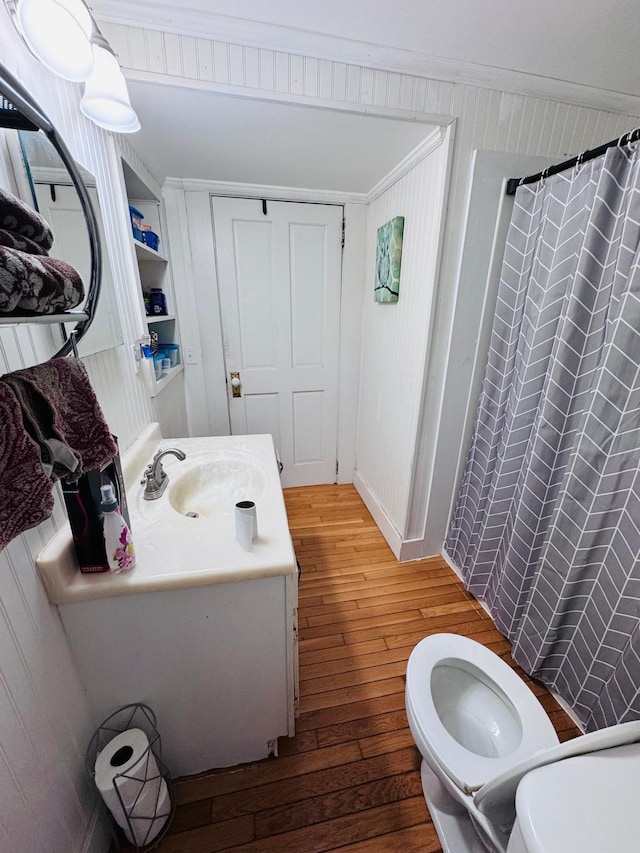 bathroom featuring vanity, a shower with shower curtain, toilet, ornamental molding, and wood-type flooring