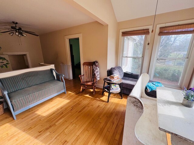 living room featuring hardwood / wood-style flooring, vaulted ceiling, and ceiling fan