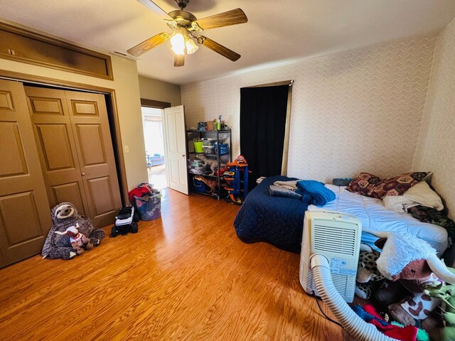 bedroom with a closet, ceiling fan, and light hardwood / wood-style flooring