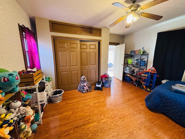 bedroom with a closet, light hardwood / wood-style flooring, and ceiling fan