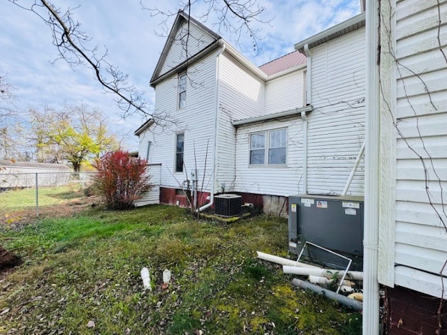 back of house featuring a lawn and central AC