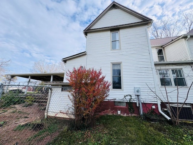 rear view of property with central AC