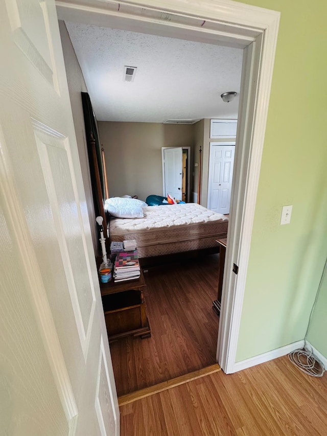 bedroom featuring hardwood / wood-style floors and a textured ceiling