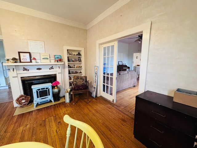 living room with hardwood / wood-style flooring, ceiling fan, and crown molding