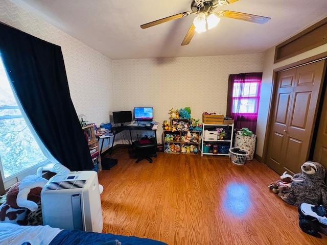 bedroom with a closet, hardwood / wood-style flooring, and ceiling fan