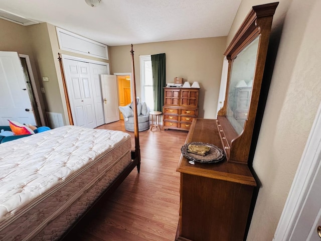 bedroom with dark hardwood / wood-style floors, a textured ceiling, and a closet