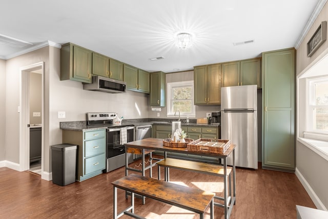 kitchen with sink, stainless steel appliances, dark hardwood / wood-style flooring, green cabinetry, and ornamental molding